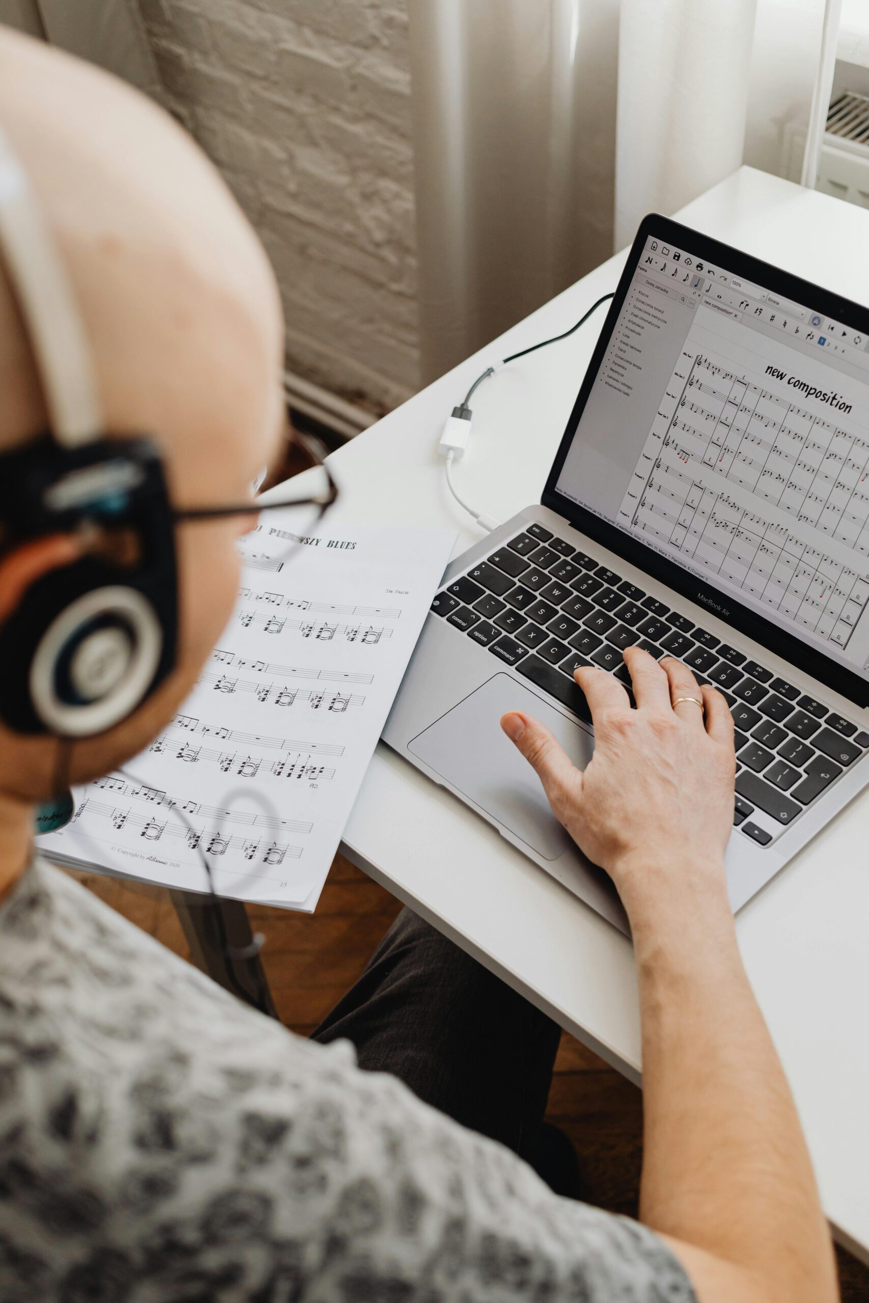 Person in front of a laptop working on sheet music